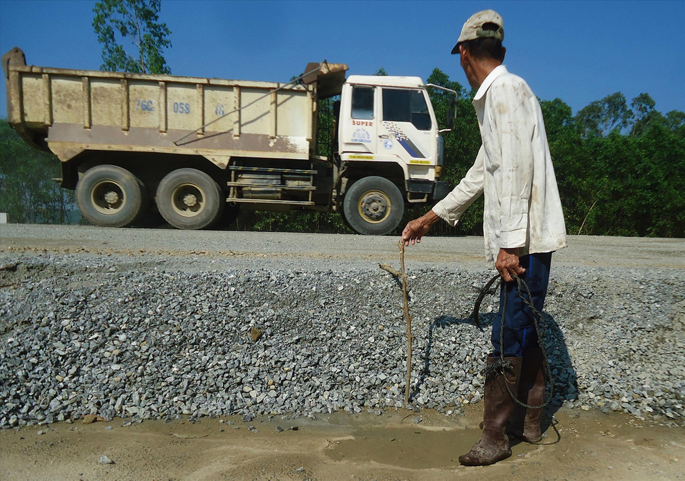 Một nông dân khác tham gia hoạt động giám sát xe chở vật liệu đi vào công trường ảnh: Văn Chương