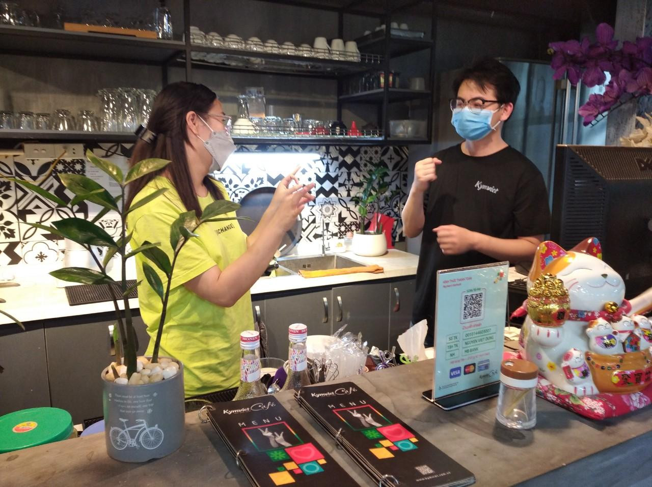 Các nhân viên giao tiếp bằng cử chỉ với nhau