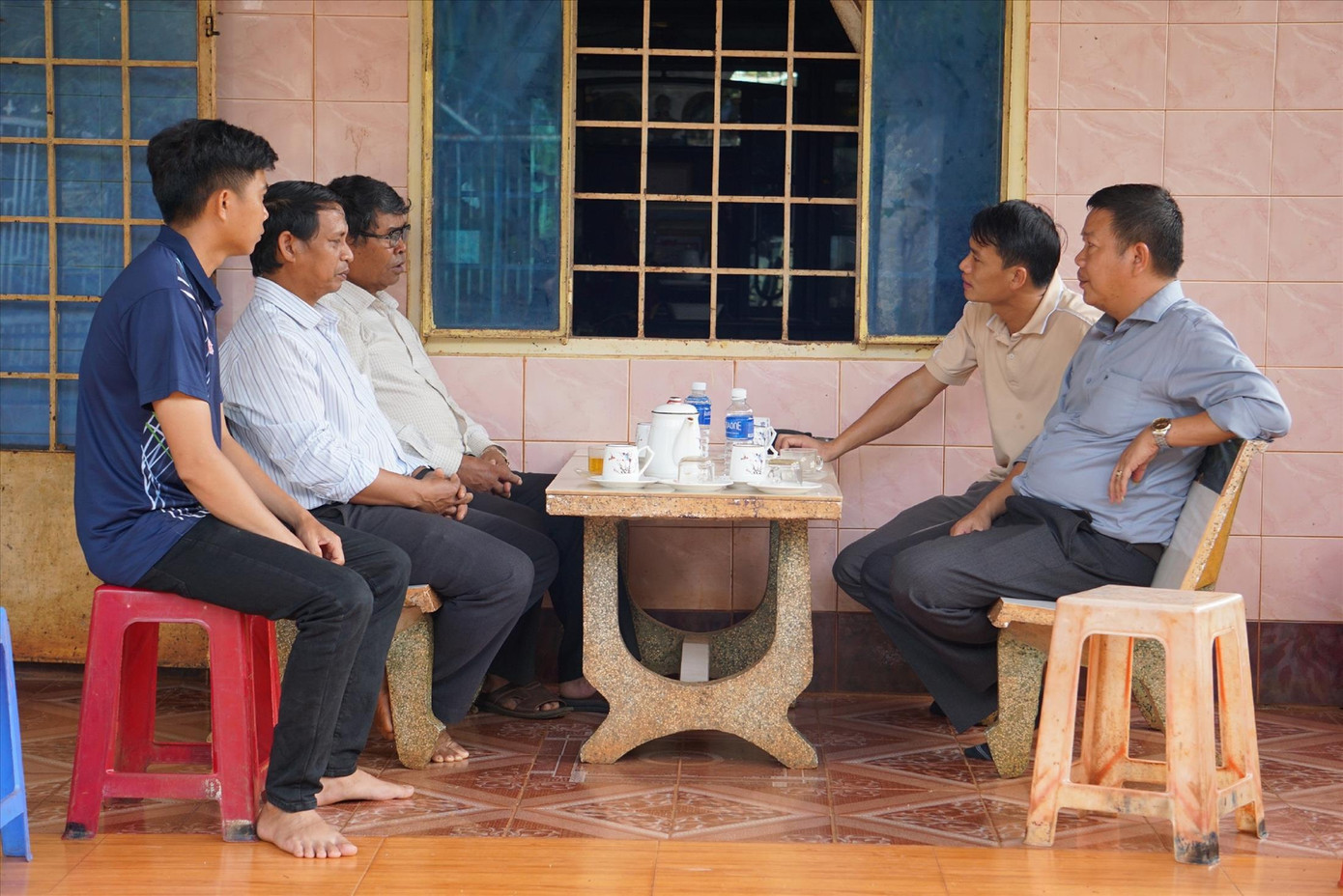 Mục sư Y Djan Êban (đeo kính) trò chuyện cùng chính quyền địa phương