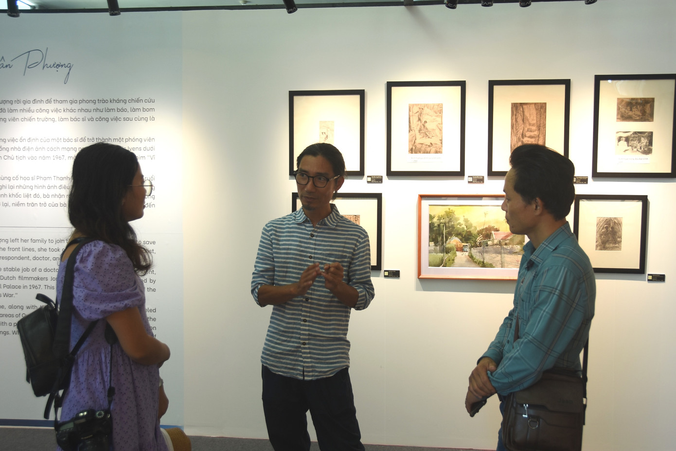 Họa sĩ Đinh Quang Hải (giữa) trao đổi với phóng viên báo chí tại triển lãm tranh “Hồi sinh”