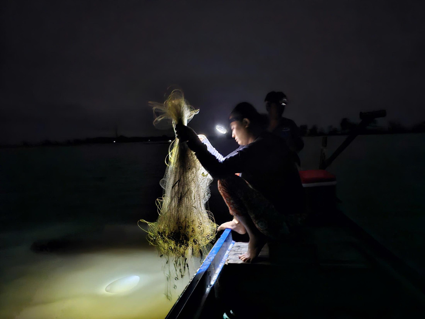 Bà Hiền đang bủa lưới trong đêm. ẢNH: HÒA HỘI