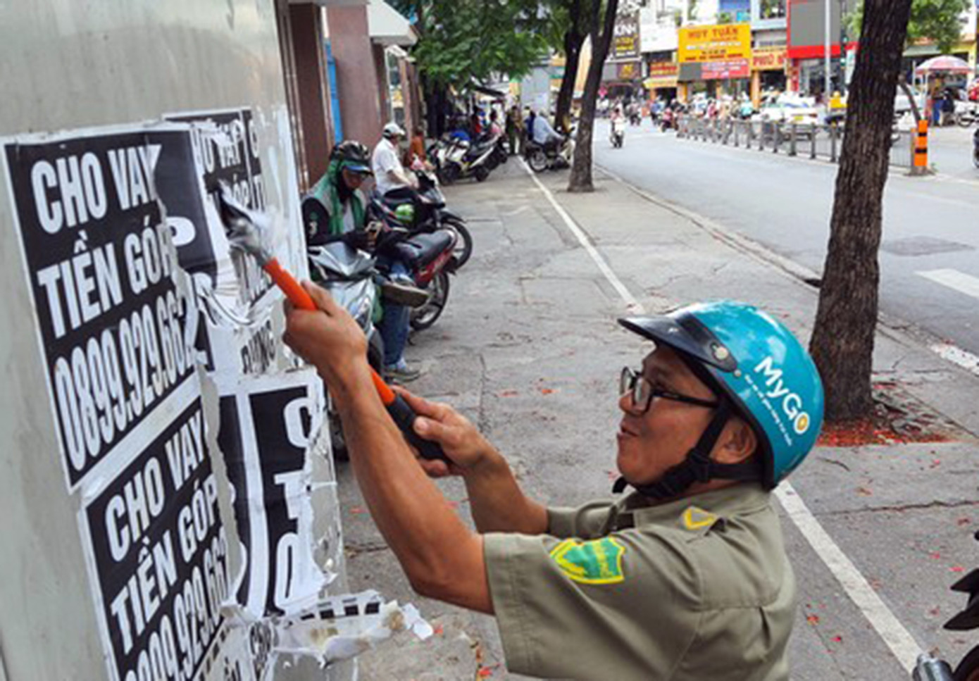 Lực lượng bảo vệ dân phố bóc, gỡ tờ rơi quảng cáo cho vay tiền dán trên tủ điện ở TPHCMẢnh: Hoàng Thuận