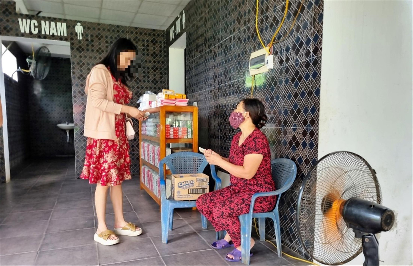 Nhân viên trạm dừng nghỉ thu tiền của khách