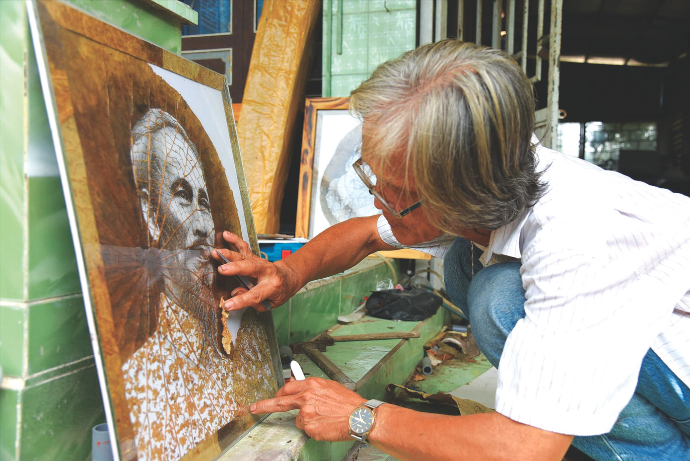 Ông Bảy Nghĩa vẽ tranh lá sen về Bác Hồ ẢNH: HÒA HỘI