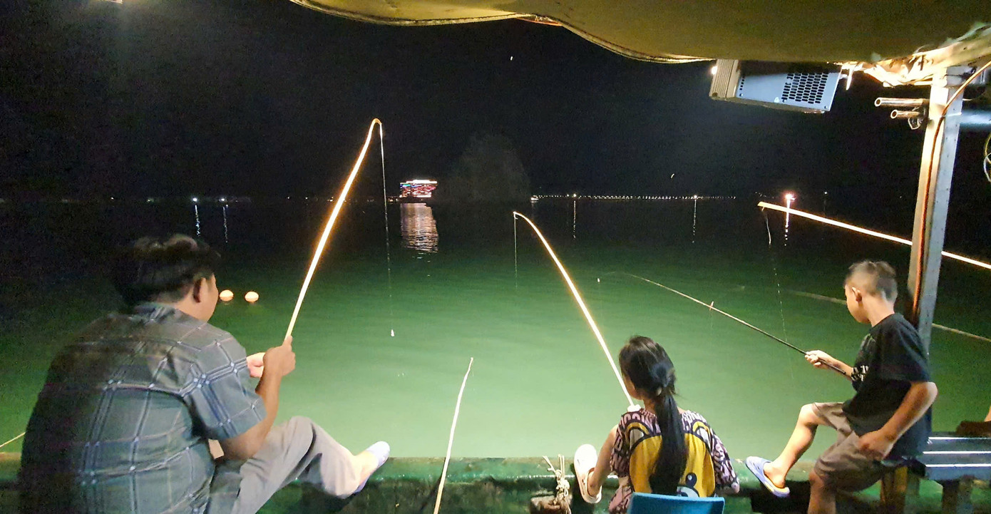 Buông câu bên mạn thuyền trên vịnh. Ảnh: Nguyễn Tuấn