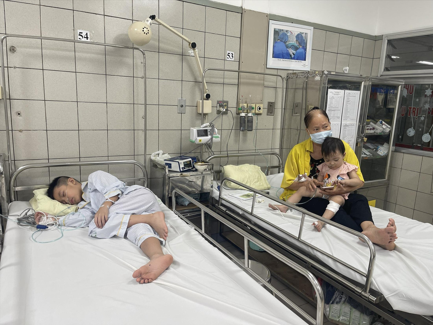 Bà Điển chăm sóc 2 cháu ngoại tại BV Bạch Mai. Ảnh: Hà Minh