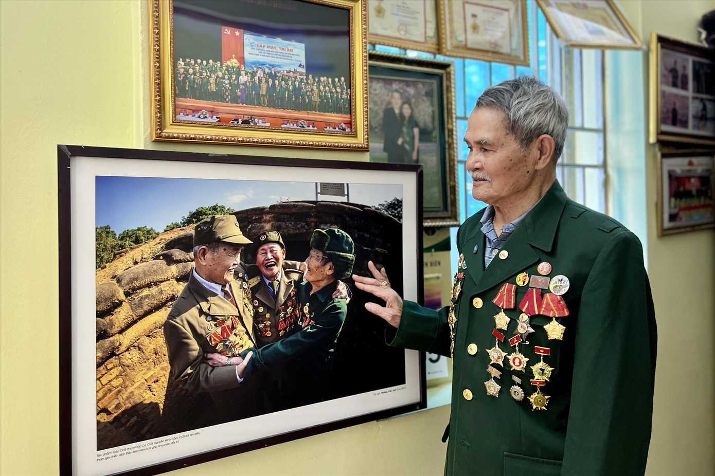 Cựu chiến binh Bùi Kim Điều xúc động nhìn lại bức ảnh kỷ niệm cùng đồng đội tại Hầm Đờ Cát.