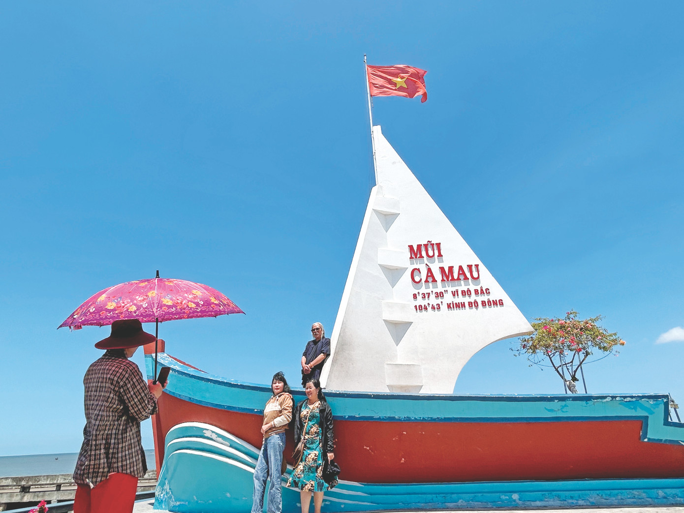 Du khách chụp ảnh tại tượng đài Đất Mũi.