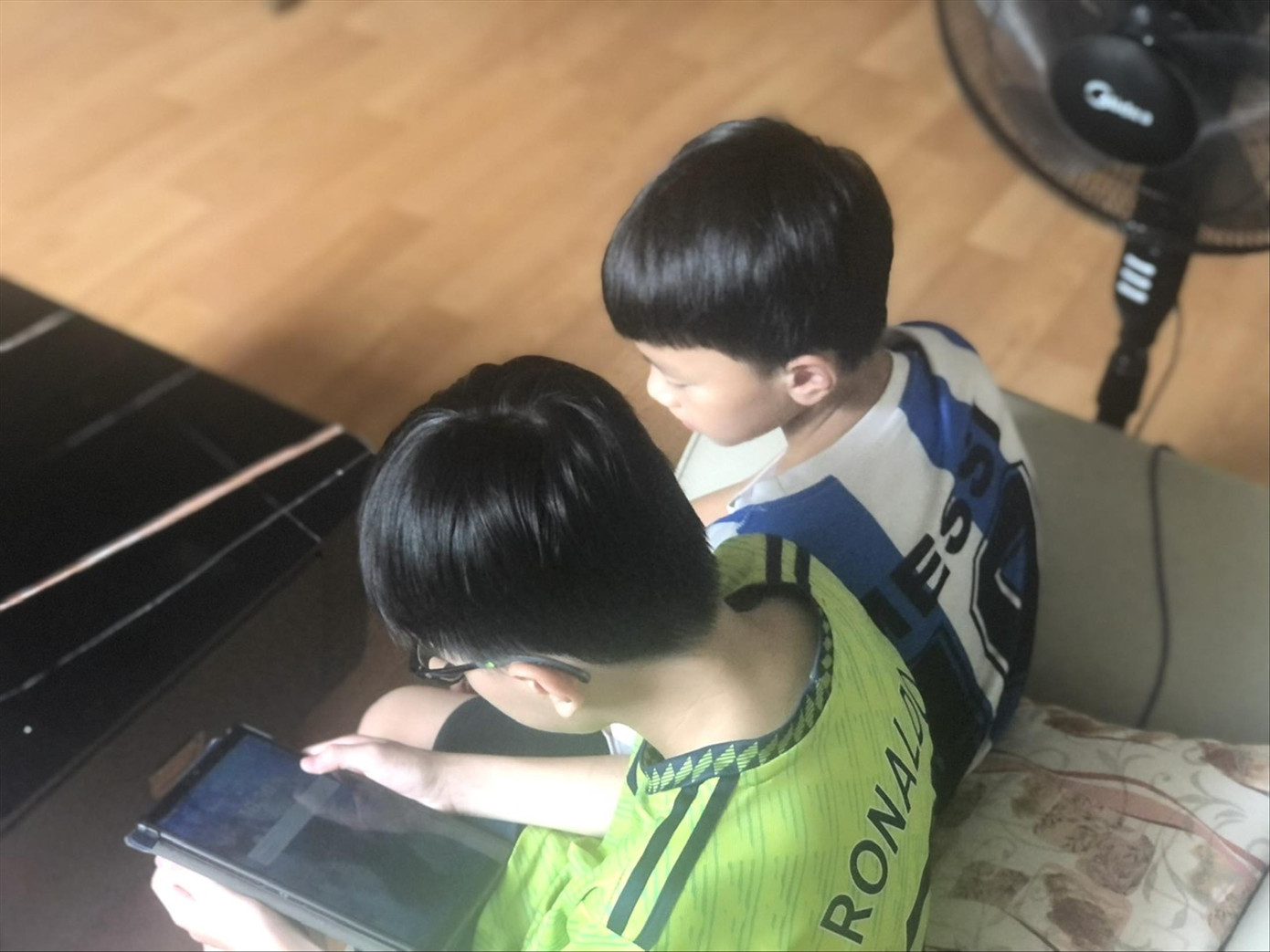 Những đứa trẻ bị giam lỏng trong nhà, làm bạn với thiết bị điện tử. Ảnh: Lưu Trinh