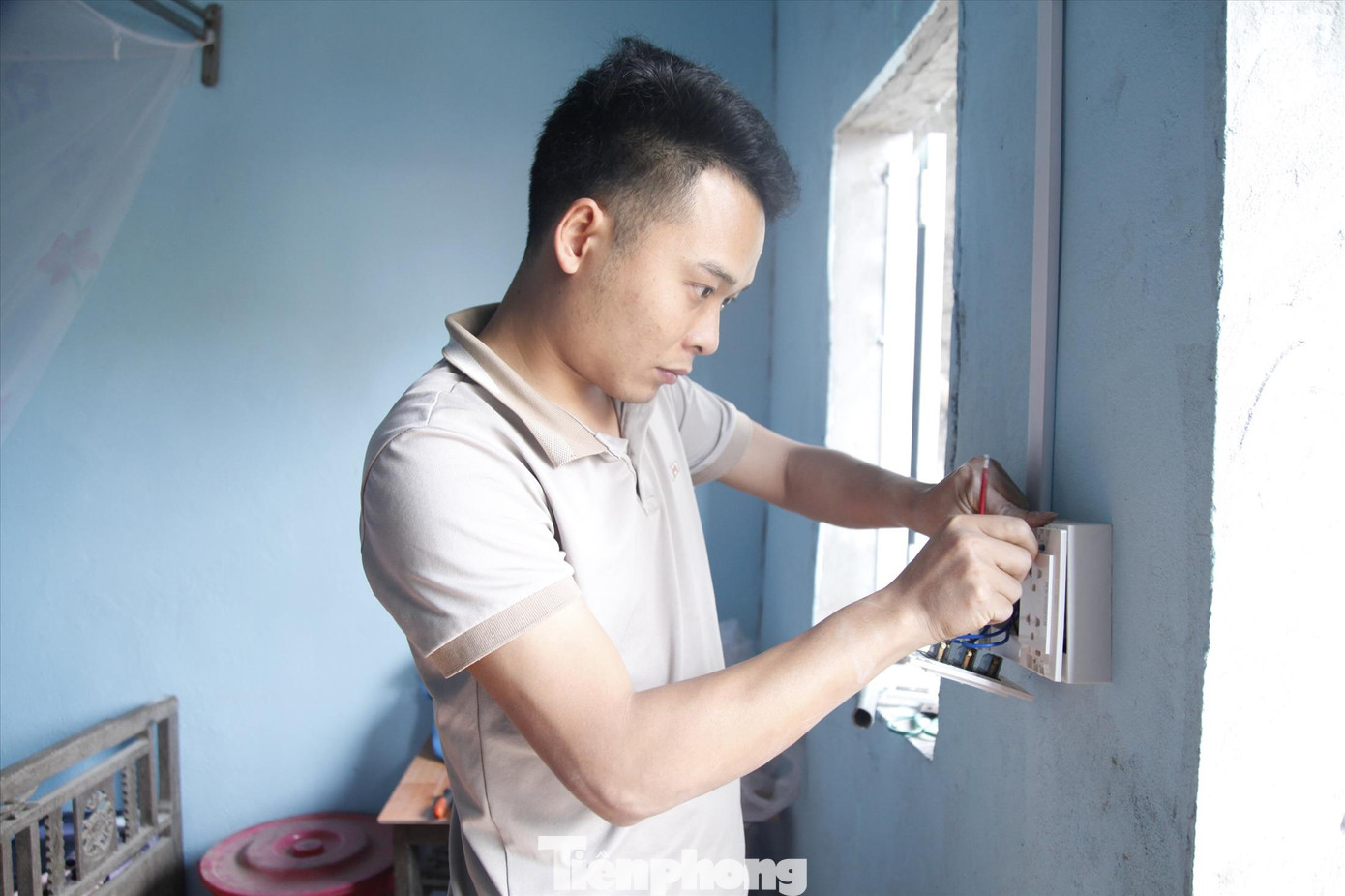 Đoàn viên Trường Cao đẳng Kỹ thuật Công nghiệp Bắc Giang làm đường dây điện giúp nhà bà Lường Thị Mèo. Ảnh: Nguyễn Thắng