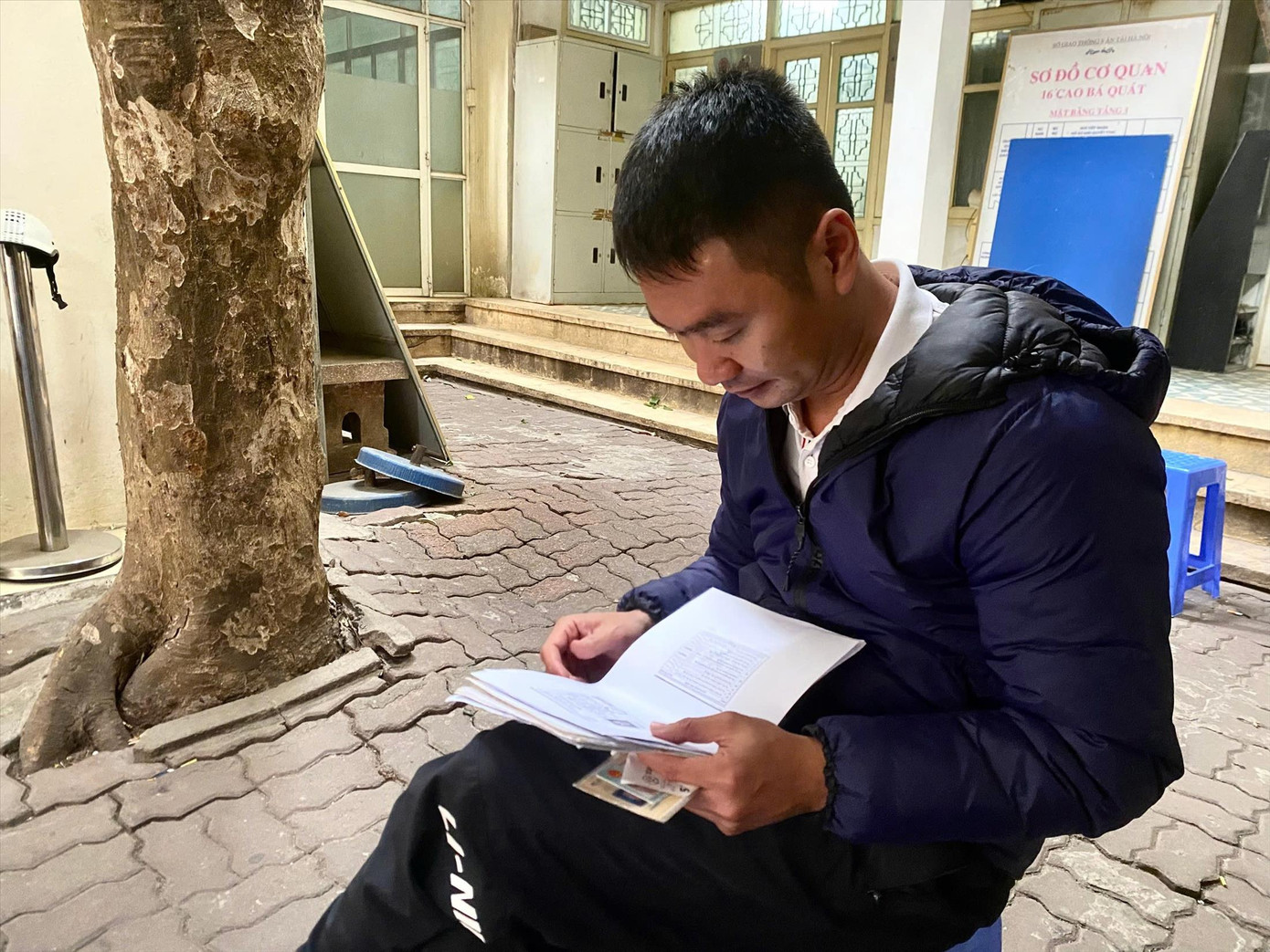 Người dân kiểm tra lại hồ sơ trước khi vào làm thủ tục xin cấp, đổi lại GPLX.