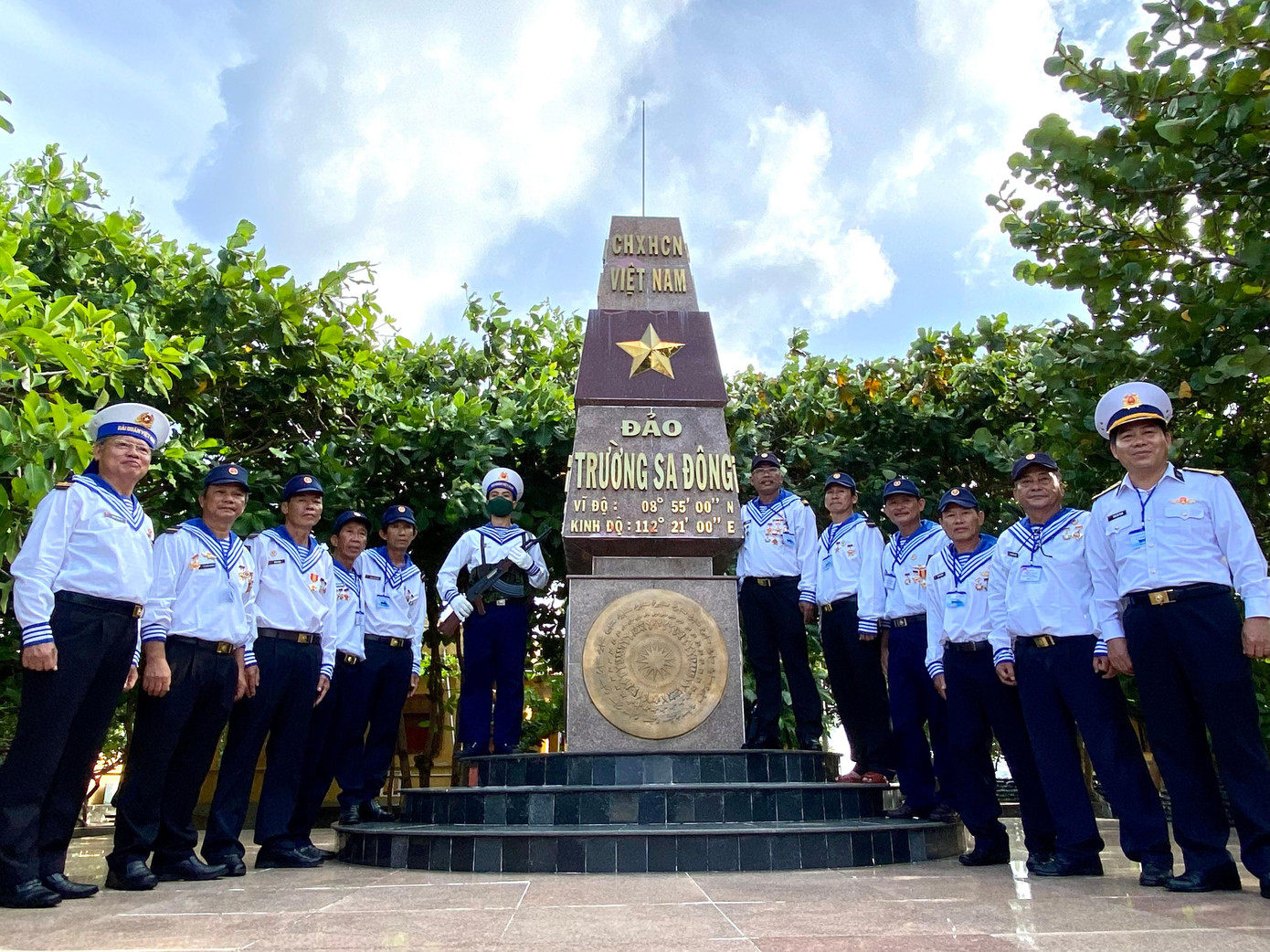 Nhóm cựu chiến binh Trường Sa Đông bên cột mốc chủ quyền Trường Sa Đông. Ảnh: Lê Xuân Sơn