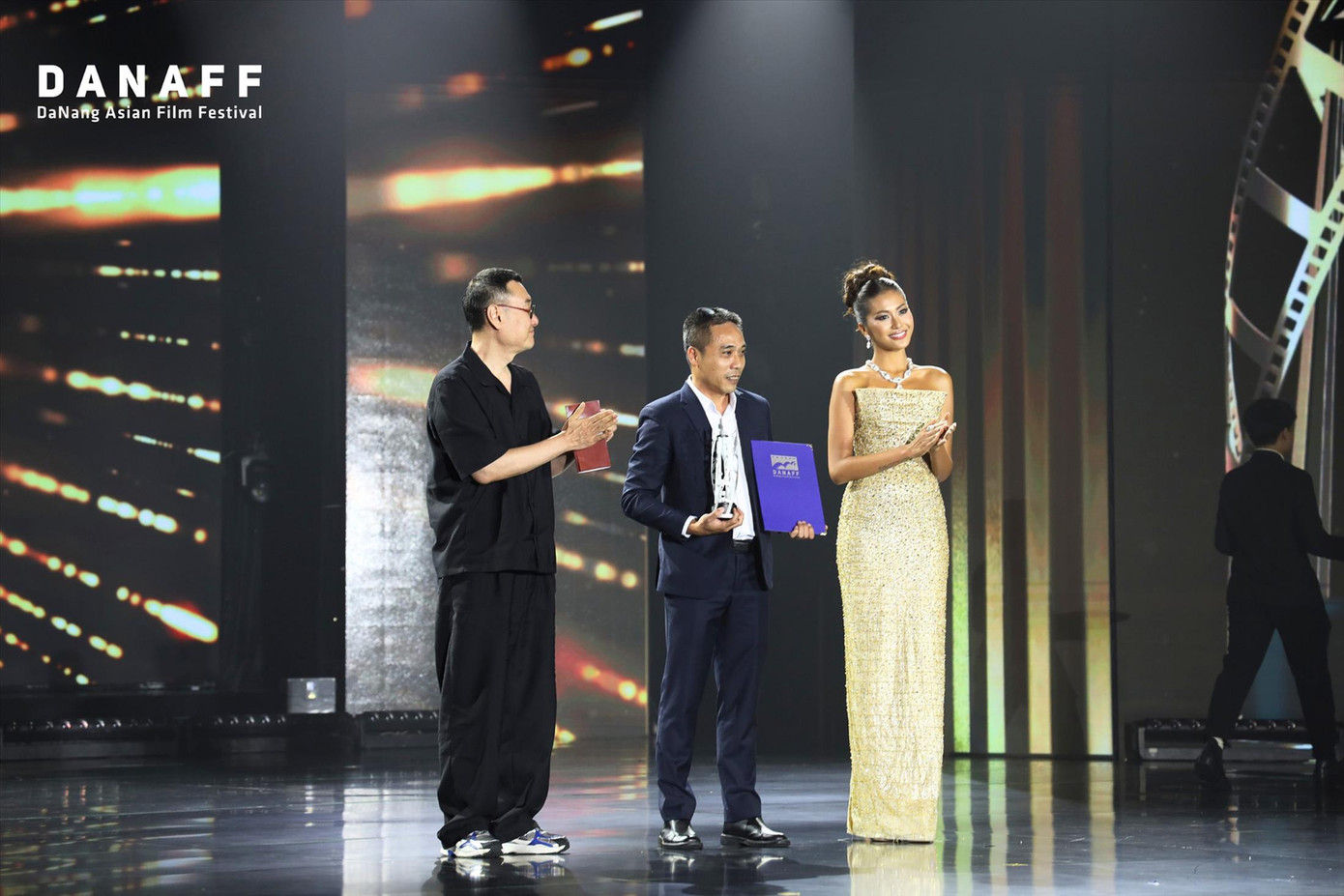 Đại diện đoàn làm phim Hắc Cẩu nhận giải đạo diễn xuất sắc nhất hạng mục phim châu Á dự thi tại LHP châu Á Đà Nẵng 3 Ảnh: DANAFF Đại diện đoàn làm phim Hắc Cẩu nhận giải đạo diễn xuất sắc nhất hạng mục phim châu Á dự thi tại LHP châu Á Đà Nẵng 3 Ảnh: DANAFF