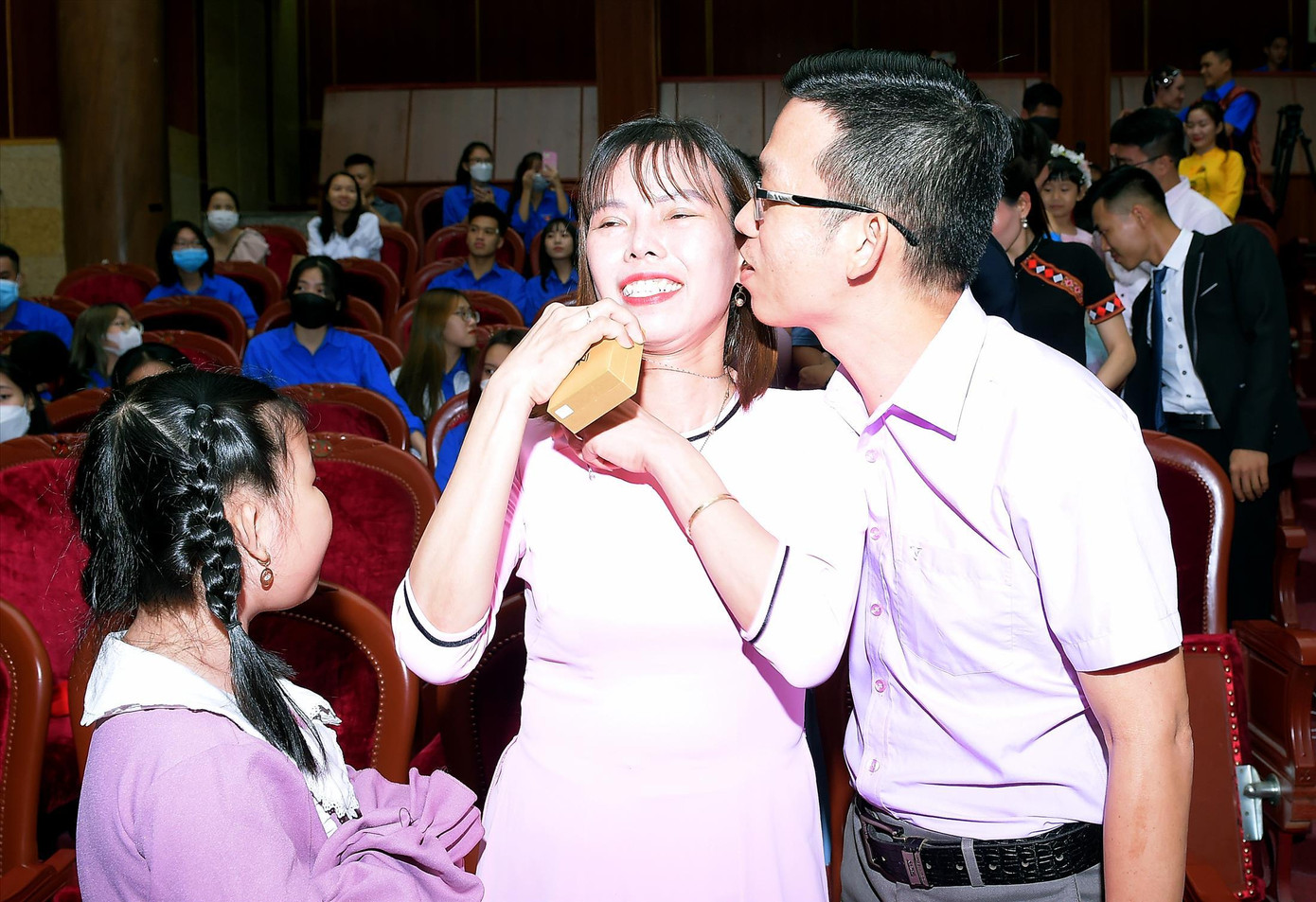 Anh Trần Mộng Hoàng (giáo viên ở Sóc Trăng) thể hiện cử chỉ yêu thương với vợ trong lễ tuyên dương &quot;Gia đình trẻ Việt Nam tiêu biểu&quot; năm 2022 Ảnh: Xuân Tùng