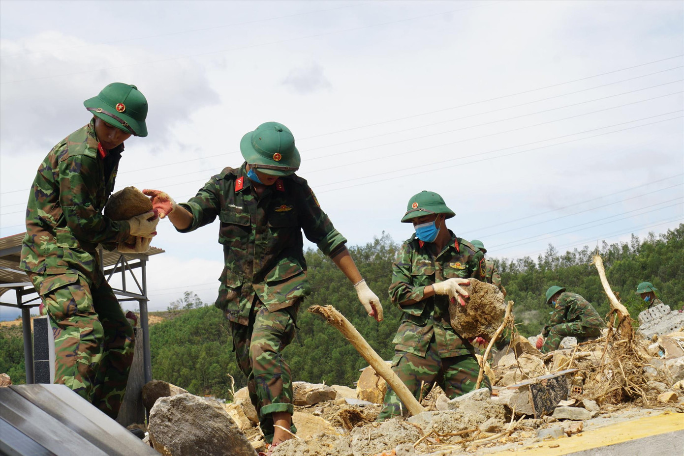 Chiến sĩ dầm mưa bốc đá khỏi nghĩa trang sạt lở. Ảnh: CTV Chiến sĩ dầm mưa bốc đá khỏi nghĩa trang sạt lở. Ảnh: CTV