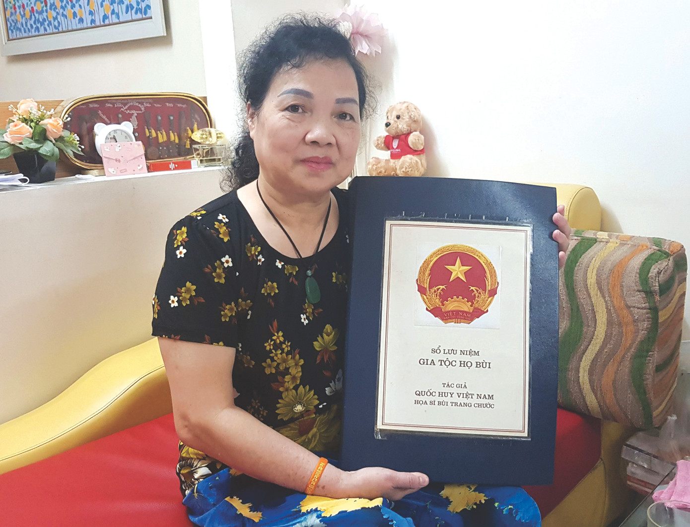 Bà Nguyễn Minh Thủy bên cuốn tư liệu về hoạ sĩ Bùi Trang Chước vẽ Quốc huy Việt Nam. Ảnh: Kiến Nghĩa.