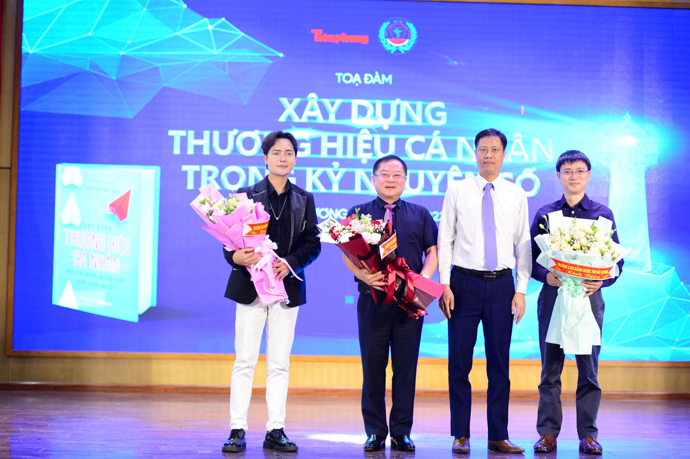 Tiến sĩ Trần Bá Kiên – Hiệu trưởng Trường Cao đẳng Dược Trung ương Hải Dương- tặng hoa cảm ơn nhà báo Lê Xuân Sơn - Tổng Biên tập báo Tiền Phong, diễn giả nhà báo Nguyễn Tuấn Anh (ngoài cùng bên phải) và ca sĩ khách mời Tuấn Phương - Á quân X-Factor 2016.