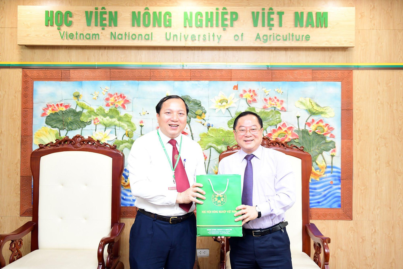 Tiến sĩ Vũ Ngọc Huyên tặng quà lưu niệm nhà báo Lê Xuân Sơn. Ảnh: Dương Triều