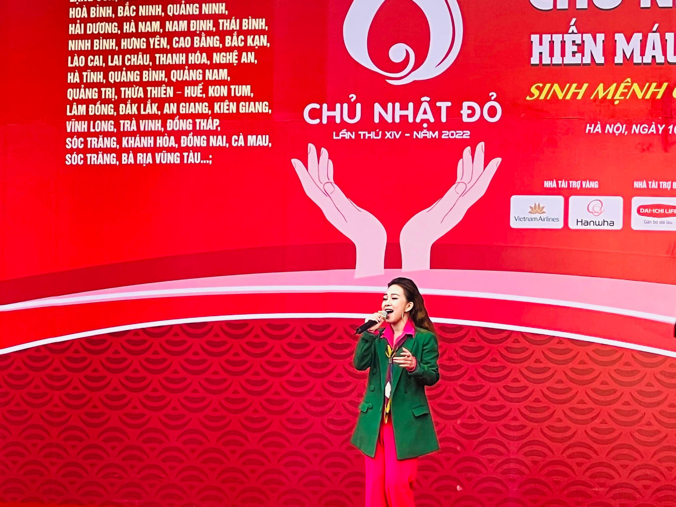 Ca sĩ Quách Mai Thy chụp ảnh cũng nhà báo Lê Xuân Sơn - Tổng Biên tập báo Tiền Phong, Trưởng BTC Chủ nhật Đỏ 2022 và diễn viên Việt Anh bên lề sự kiện.