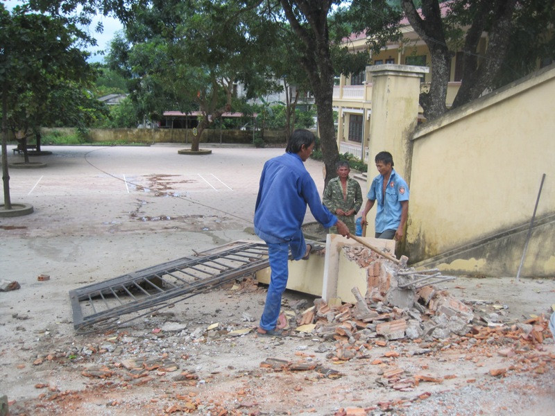 Chiếc xe tải nát bét phần đầu sau khi cả một khối lượng bê tông của cổng trường đè xuống