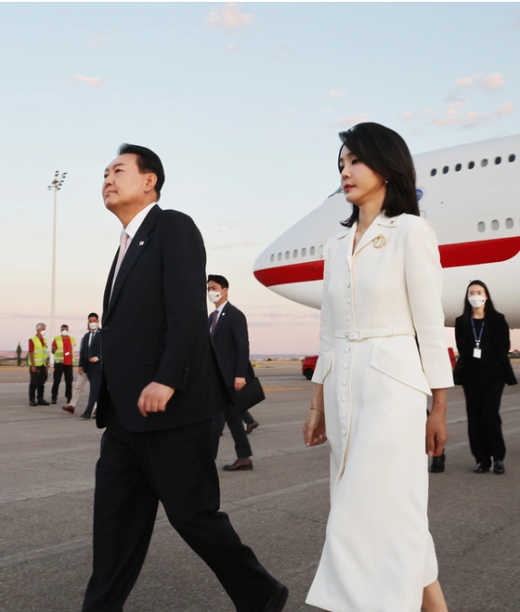 Lối ăn mặc của bà Kim không lạ đối với phương Tây. Set đồ trắng nổi bật, cài áo nhấn đơn giản là công thức muôn đời của các thành viên Hoàng gia.