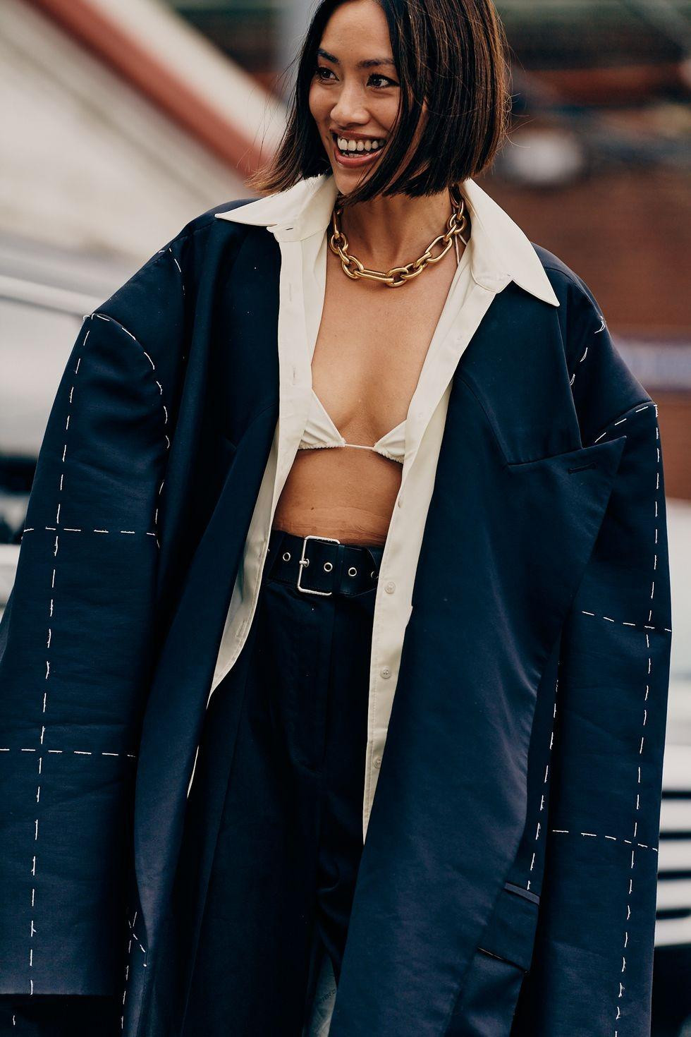 Phụ kiện đi cùng như choker vàng càng làm nổi bật chiếc áo khoác quá khổ.