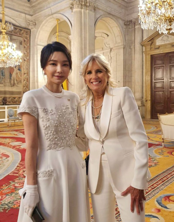 Đứng cạnh Đệ nhất phu nhân Mỹ Jill Biden, bà Kim vẫn đẹp tinh tế nhờ các chi tiết thêu nổi tinh xảo trên áo, cùng tone màu trắng nên không phá tổng thể.