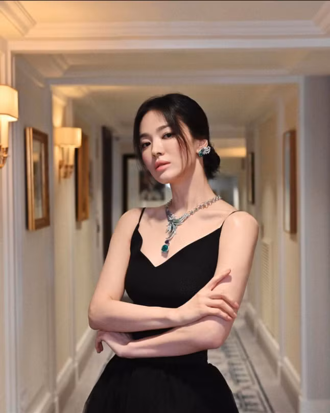 Không chỉ hướng ánh mắt người nhìn dọc xuống, chiếc đầm cổ chữ V này còn giúp cô khéo léo khoe xương quai xanh đầy thanh lịch, làm nổi bật trang sức.