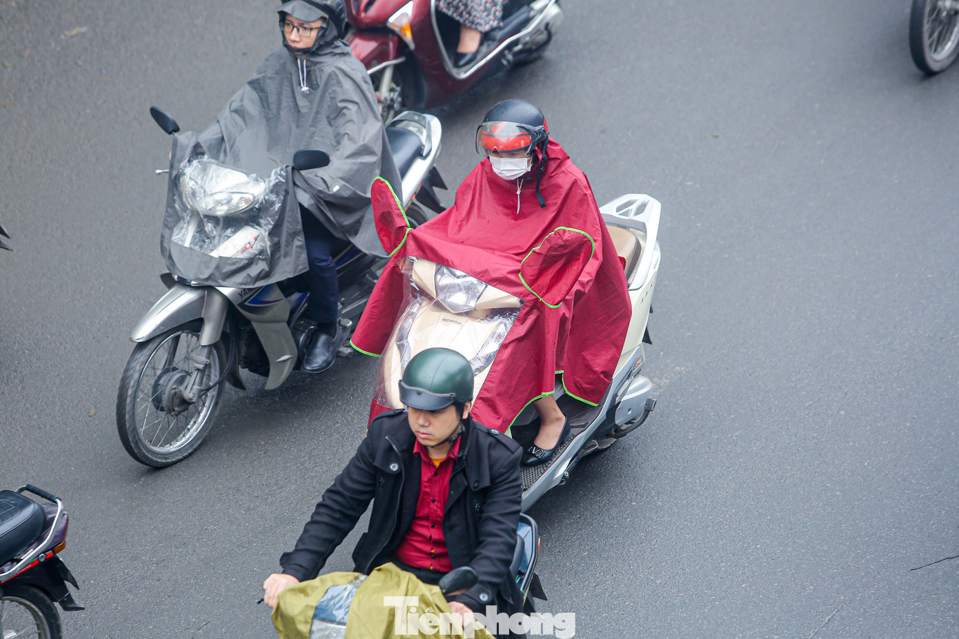 Mưa phùn gây cảm giác khó chịu, nhiều người cẩn thận mặc áo mưa.