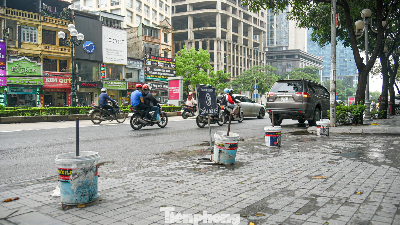 Những cục bê tông đổ trong các thùng sơn cũ được tận dụng làm cọc ngăn trên vỉa hè đường Lê Văn Lương (quận Thanh Xuân).