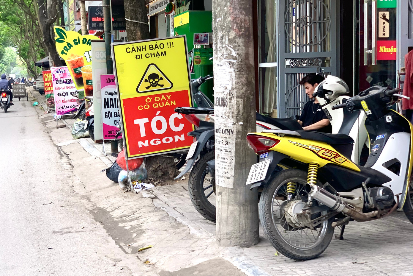 Biển quảng cáo, xe máy chi chít trên vỉa hè đường 19/5.