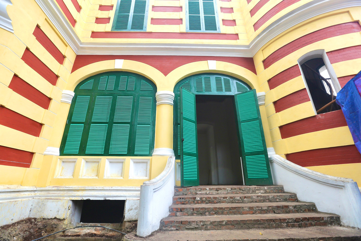 Kiến trúc của căn biệt thự được giữ nguyên lớp sơn vàng, cửa xanh