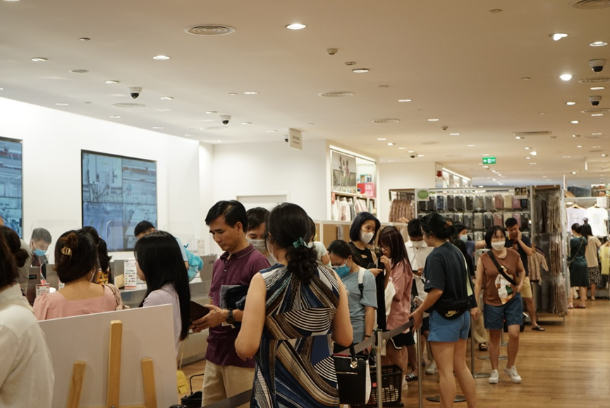 Đoàn người xếp hàng dài chờ thanh toán trong khu mua sắm quần áo. Nhiều người chờ nửa tiếng mới đến lượt.