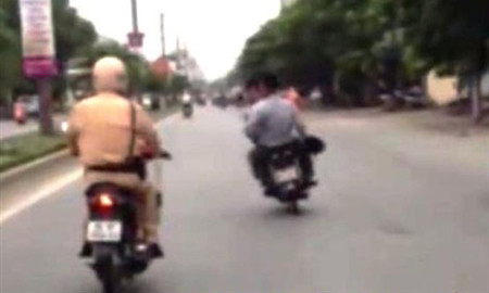 Ngọc và Kỷ chạy xe máy không đội MBH, lạng lách trêu tức CSGT (ảnh cắt từ clip).
