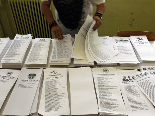 Một phụ nữ sắp xếp phiếu bầu ở Athens hôm 17-6. Ảnh: AP 