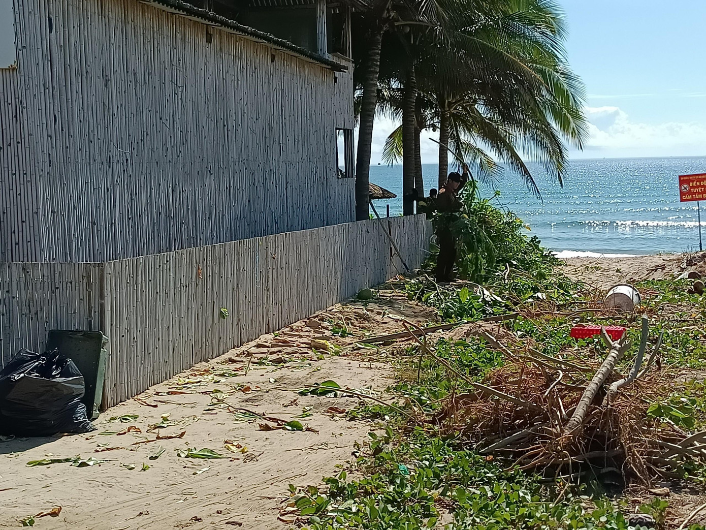 Công nhân khu du lịch The Anam đang dọn dẹp lối đi xuống biển Công nhân khu du lịch The Anam đang dọn dẹp lối đi xuống biển