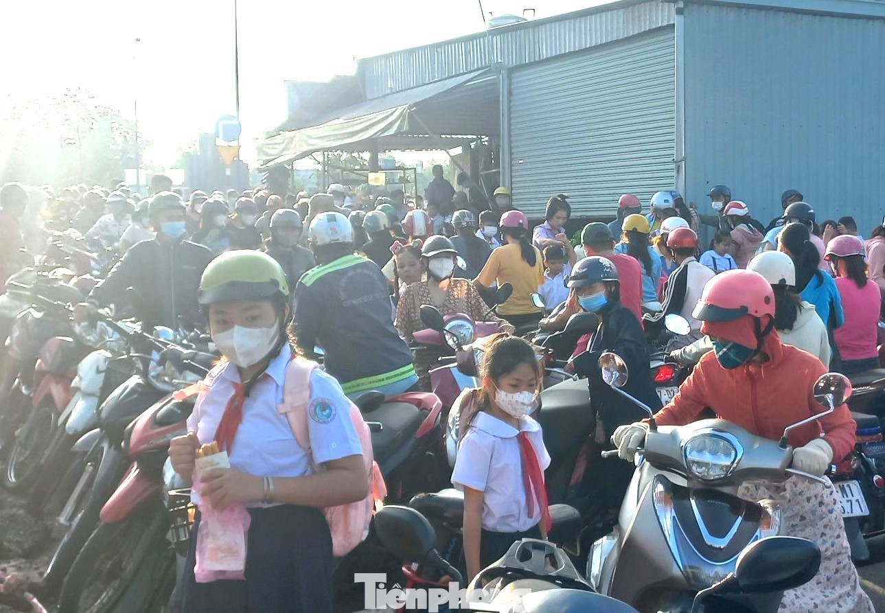 Học sinh ăn vội ổ bánh mì trước khi vào trường