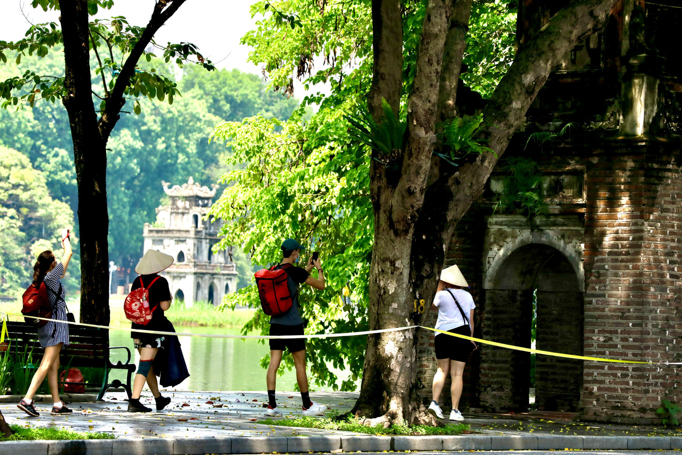 Những du khách này đã mải mê với vẻ đẹp của hồ Gươm trong mùa thu mà vô tình đi vào trong rào chắn bằng dây ngăn người dân tụ tập để phòng chống COVID-19.