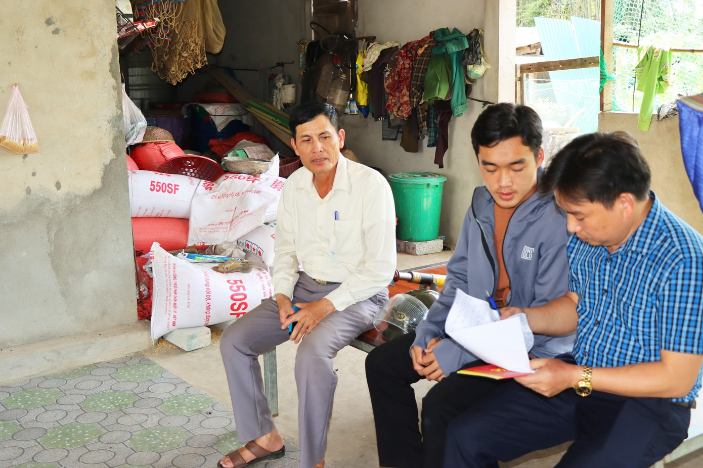 Em Bùi Đình Thắng (ở giữa) đón nhận những tình cảm của người dân hỗ trợ gia đình.