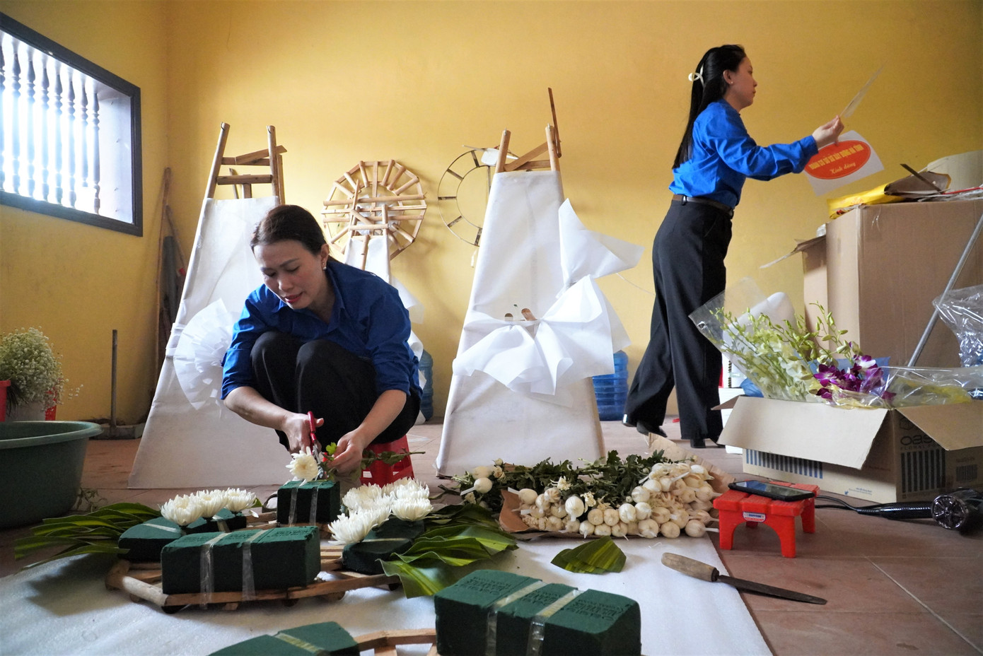 Ngoài nhiệm vụ thuyết minh, nhân viên tại đây còn cắm hoa hỗ trợ khách đến dâng hương tưởng niệm.