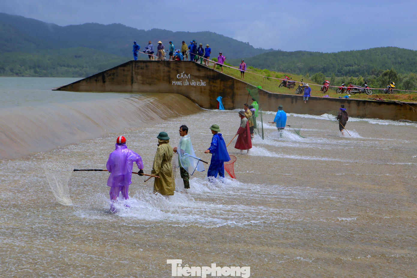 Khu vực này có hàng chục người tập trung hai bên cánh gà tại phần xả tràn của đập để bắt cá. Họ chuẩn bị các dụng cụ tự chế như vợt, lưới để bắt cá khi cá trôi ra từ dòng nước chảy qua tràn.