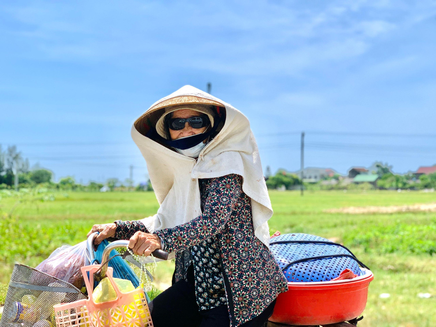 Người phụ nữ bịt kín mít, đạp xe về nhà sau khi đi chợ bán rau trở về.