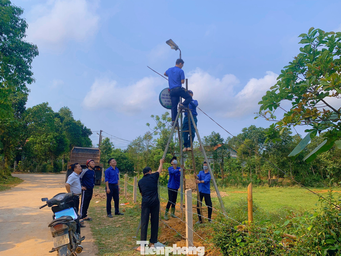 Lực lượng thanh niên tổ chức lắp hệ thống đèn điện chiếu sáng tại đường quê.