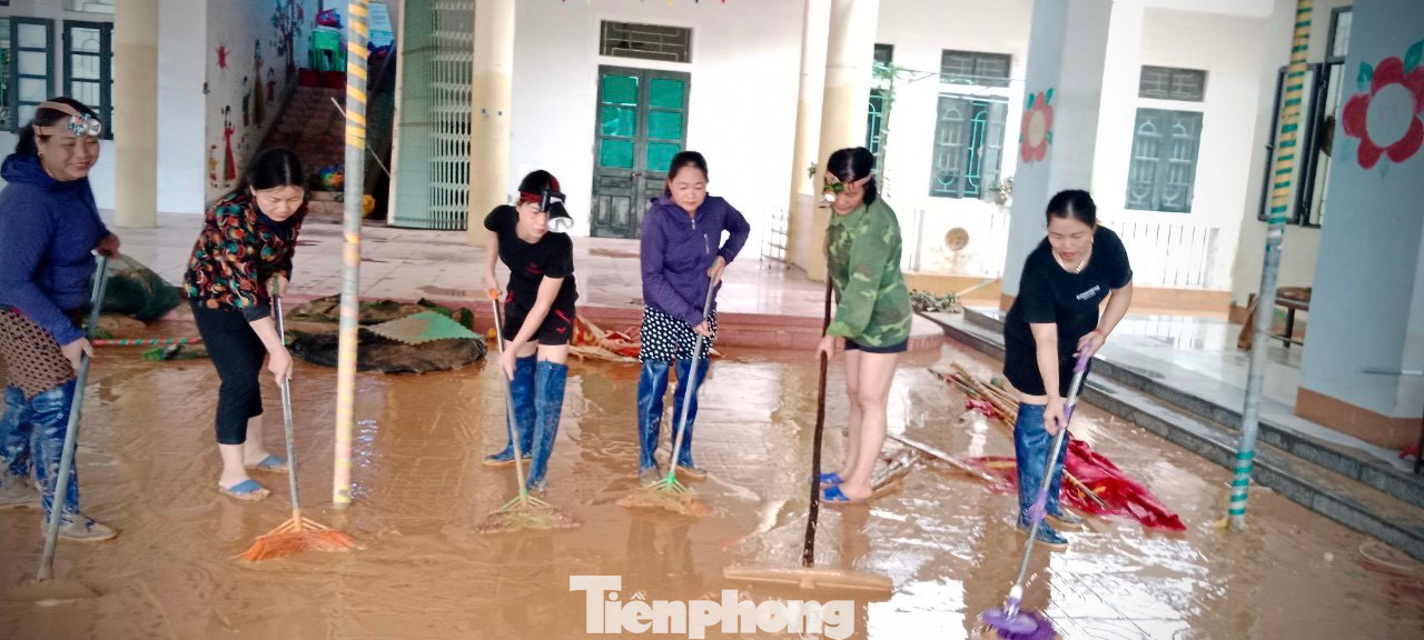 Cô Sự (áo hoa thứ 2 bìa trái) cùng giáo viên trong trường dọn bùn sau lũ.