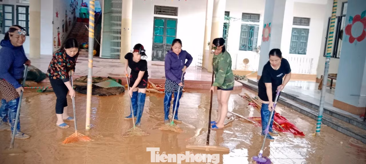 Cô Sự (áo hoa thứ 2 bìa trái) cùng giáo viên trong trường dọn bùn sau lũ.