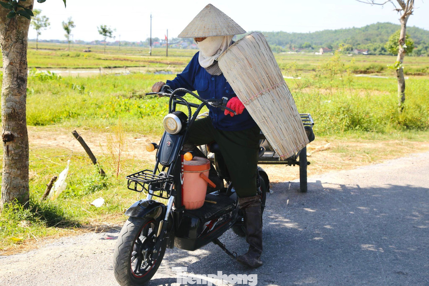 Mọi người ra đồng với trang phục kín mít để chống nắng.