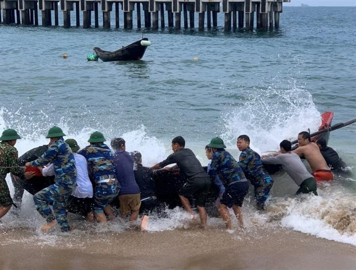Chính quyền địa phương cùng lưc lượng bộ đội đưa con thuyền gặp nạn vào bờ.