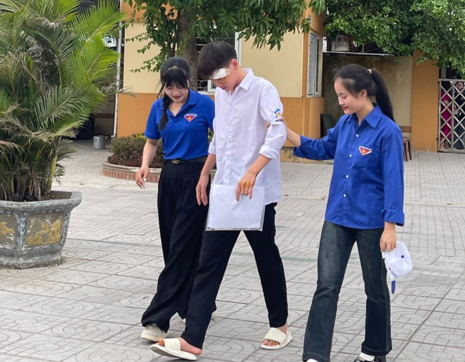 Các tình nguyện viên hỗ trợ thí sinh vào phòng thi.