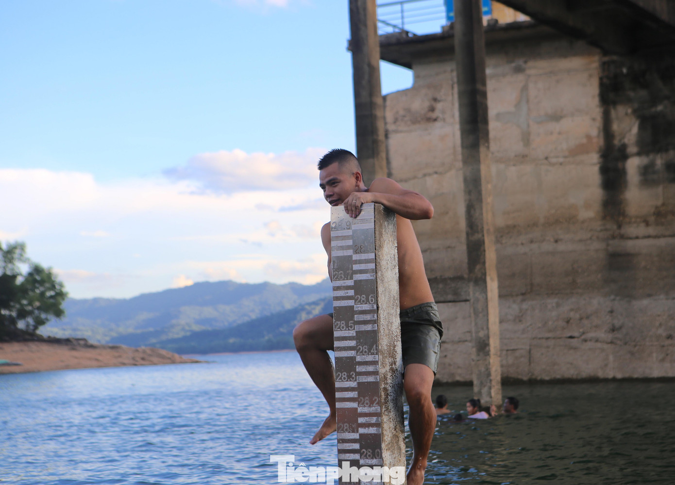 Những thanh niên cố trèo lên tại các cột bê tông để nhảy xuống hồ.