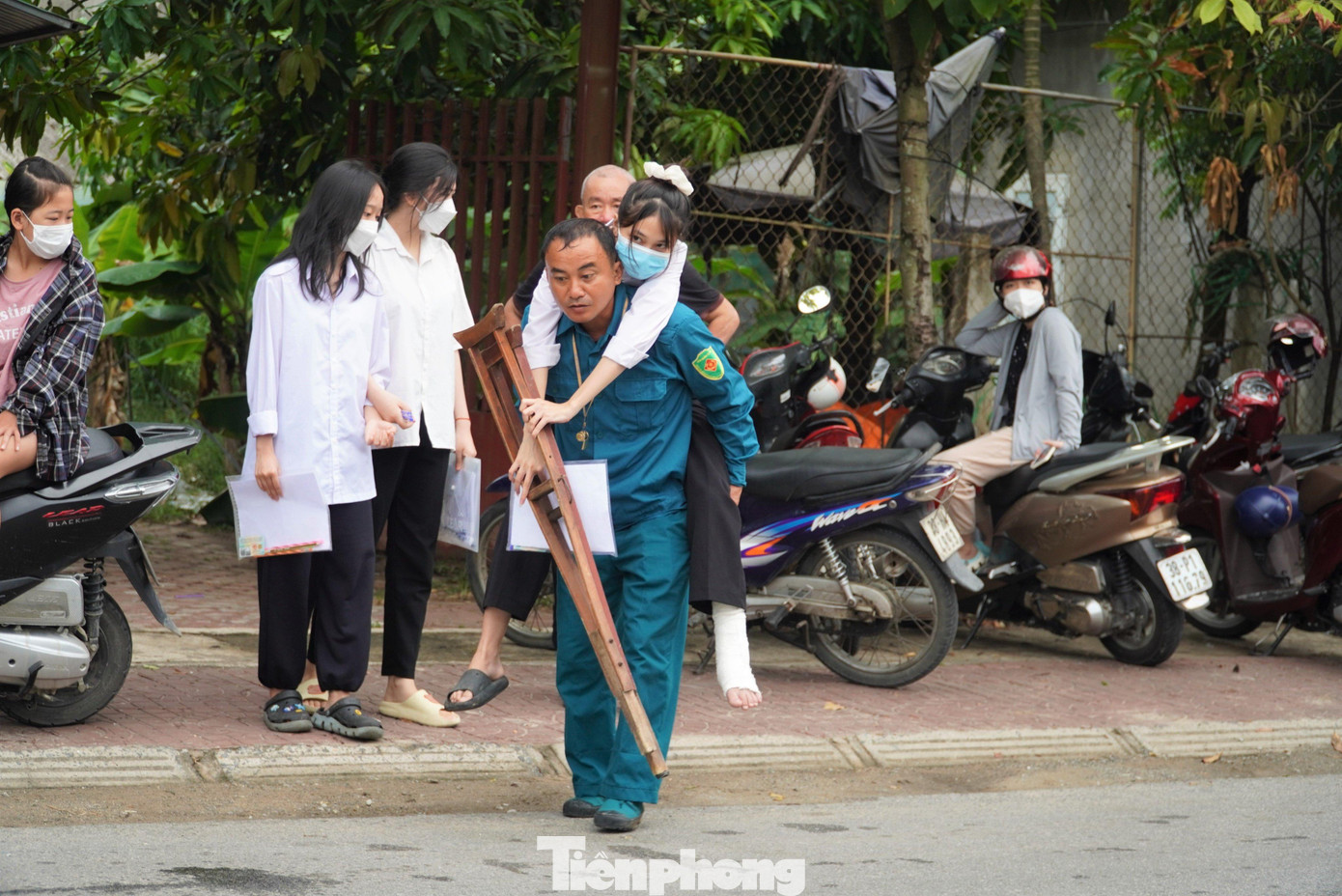 Ông Lý cõng con gái trên lưng đến điểm thi. Ông Lý cõng con gái trên lưng đến điểm thi.